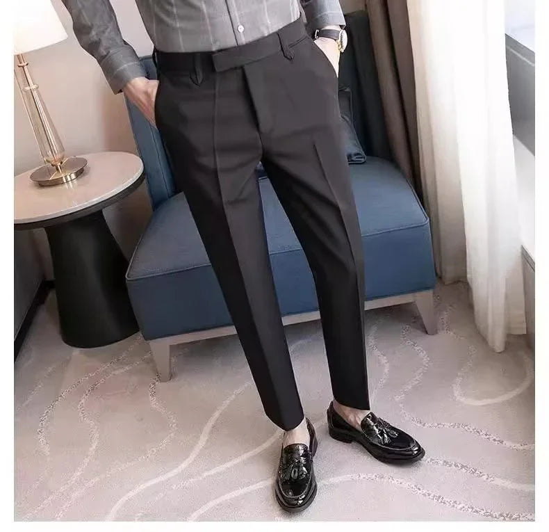 Man wearing tailored black dress pants and black tassel loafers standing in modern room