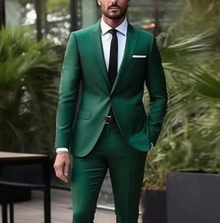 Man wearing a fitted green suit with black tie and white shirt in an outdoor garden setting
