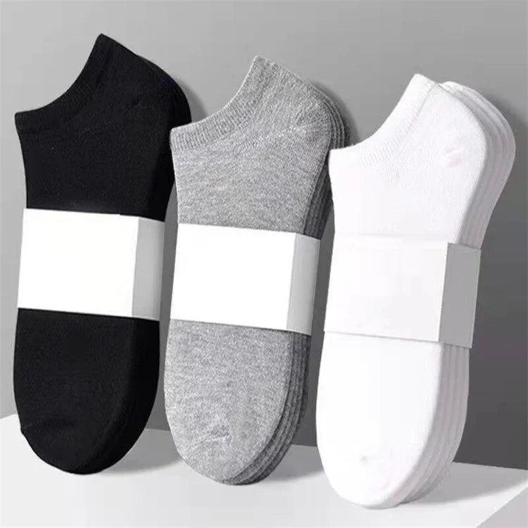 Sets of black, gray, and white ankle socks neatly stacked with plain white packaging bands