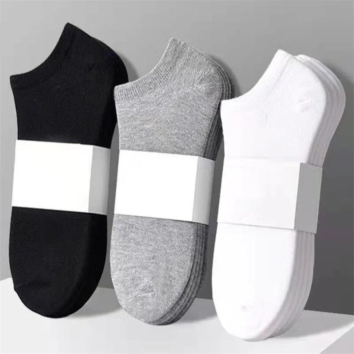 Sets of black, gray, and white ankle socks neatly stacked with plain white packaging bands