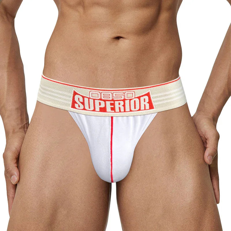 male model wearing white jockstrap underwear with red trim and beige elastic waistband labeled OBSC Superior