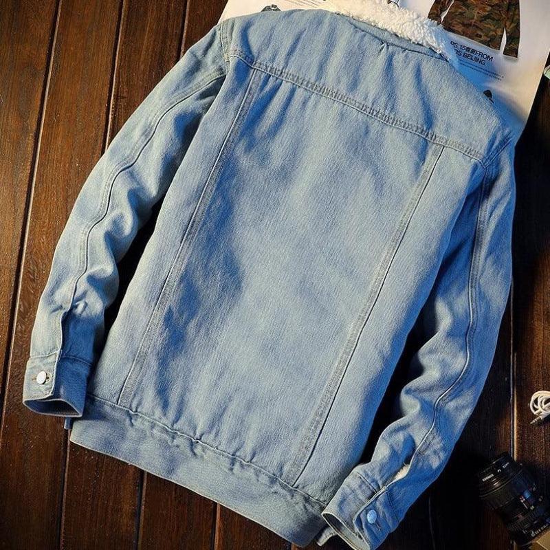 Light blue denim jacket with white sherpa collar laid flat on wooden surface, casual outerwear style