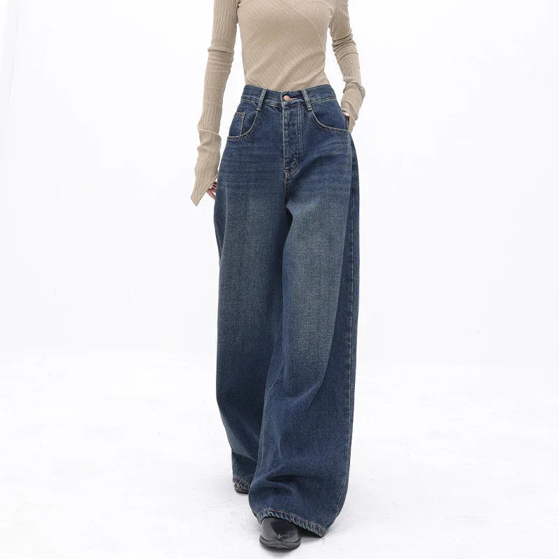 Woman wearing high waist wide leg dark blue denim jeans and beige ribbed long sleeve top