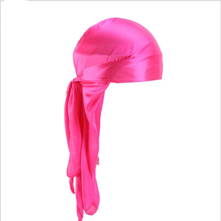Bright pink satin durag with long flowing tail on white background