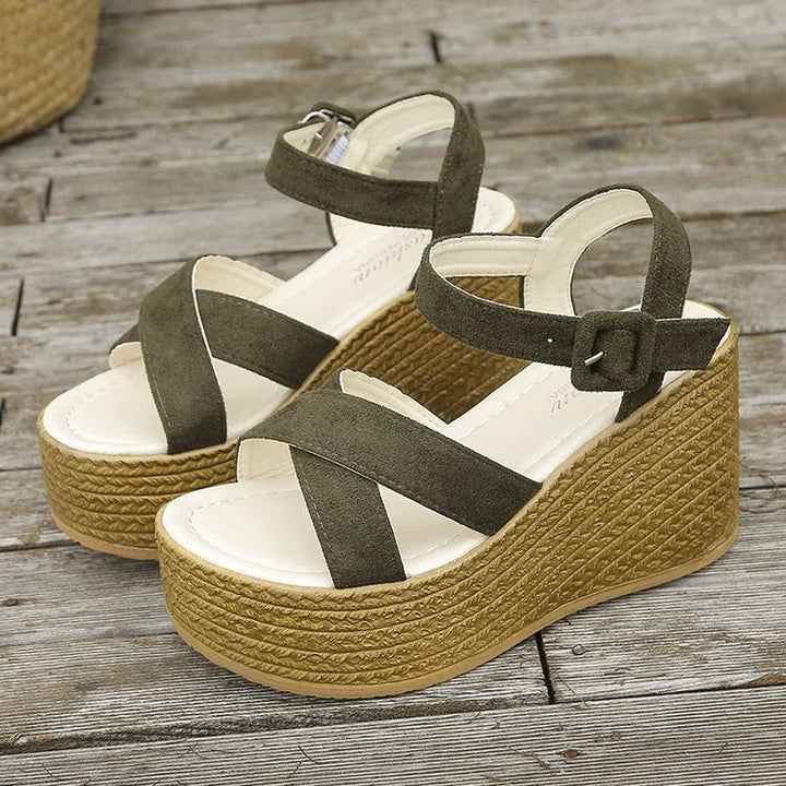 olive green suede platform wedge sandals with buckle strap on wooden floor