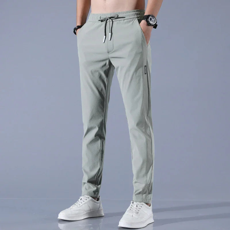 man wearing light gray slim-fit jogger pants with drawstring waist and white sneakers