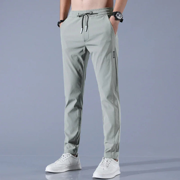 man wearing light gray slim-fit jogger pants with drawstring waist and white sneakers