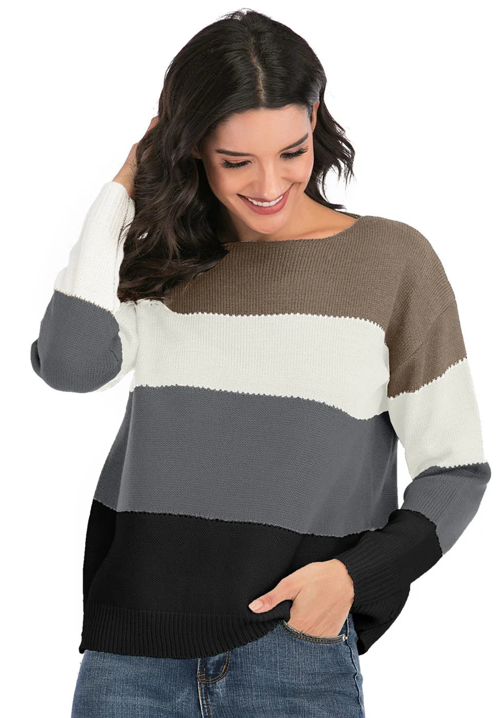 Smiling woman wearing color block knit sweater in brown, white, gray, and black with jeans