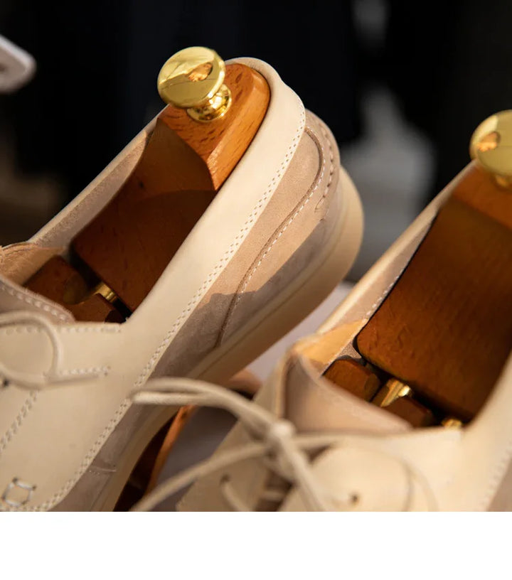 Close-up of beige leather casual shoes with wooden shoe trees and gold knobs