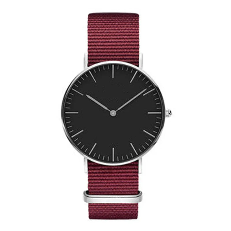 Minimalist wristwatch with black dial and silver case on a burgundy nylon strap