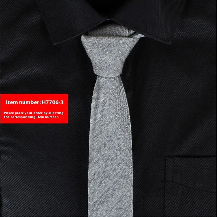 Silver textured slim necktie on black dress shirt with collar and pocket