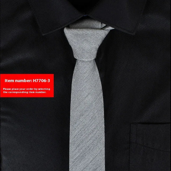 Silver textured slim necktie on black dress shirt with collar and pocket