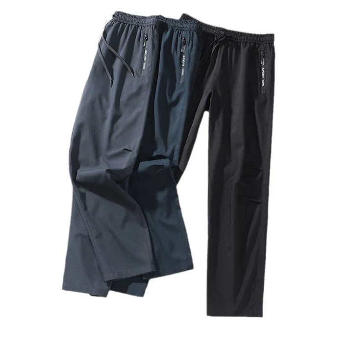 Two pairs of casual men's sport pants in navy blue and black with elastic waist and zippered pockets