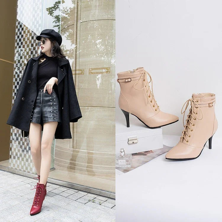 Stylish woman in black coat and shorts wearing red lace-up high heel ankle boots next to beige high heel lace-up ankle boots