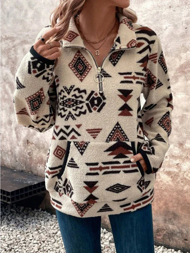 Woman wearing beige fleece pullover with black and brown Aztec tribal patterns and front pocket