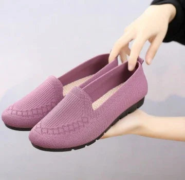 Light purple knitted casual slip-on shoes with cushioned soles held by hands