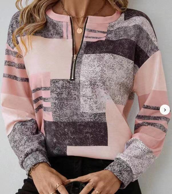 Woman wearing a pastel pink and grey geometric print long-sleeve top with a front zipper detail
