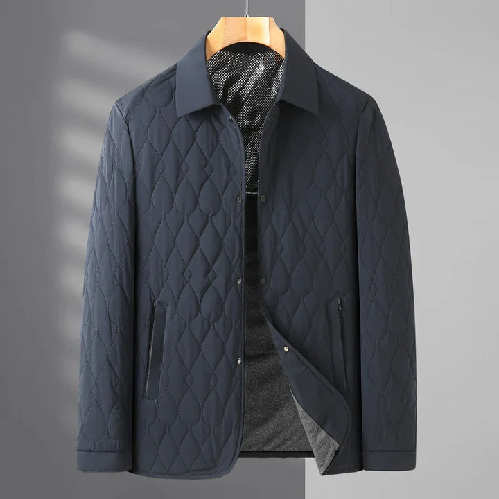 Men's dark blue quilted lightweight jacket with collar and zippered pockets on hanger