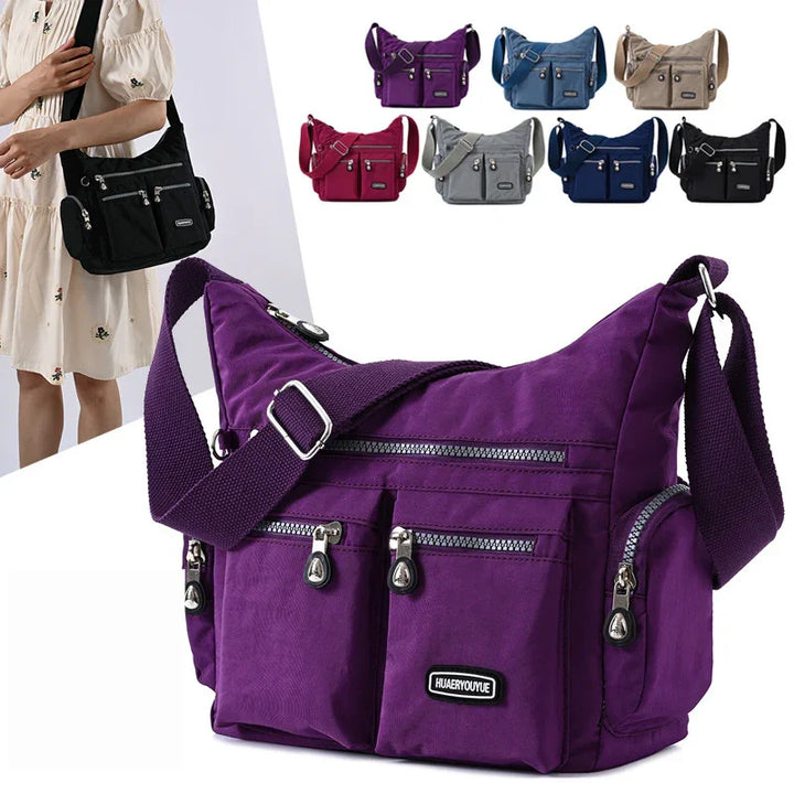 Purple crossbody shoulder bag with multiple zippered pockets and adjustable strap, shown in various colors