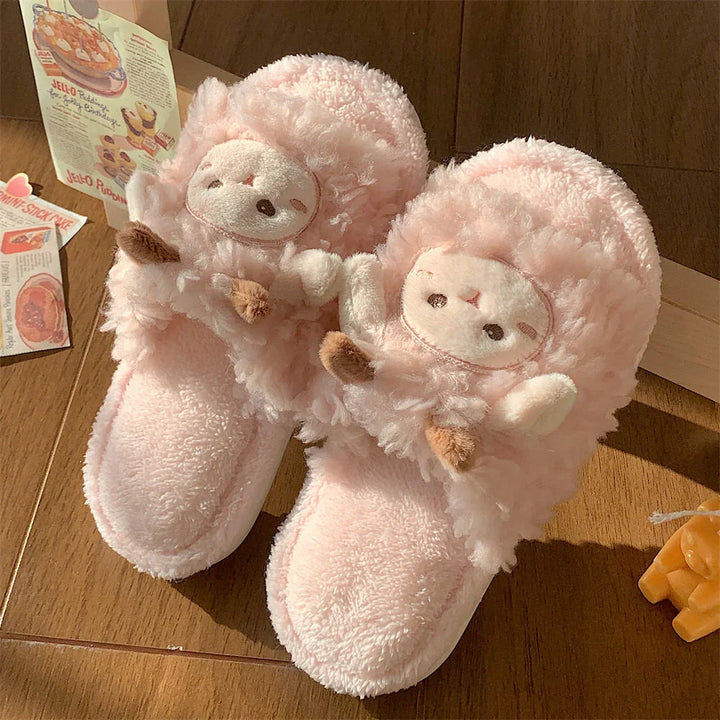 Soft pink fluffy slippers with cute animal faces on wooden floor with vintage postcards