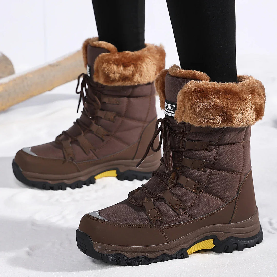 Brown winter hiking boots with fur lining worn on snow, featuring black soles and lace-up design
