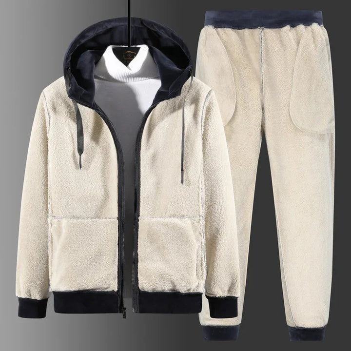 Beige fleece hoodie and jogger pants set with black cuffs and hood lining on gray background