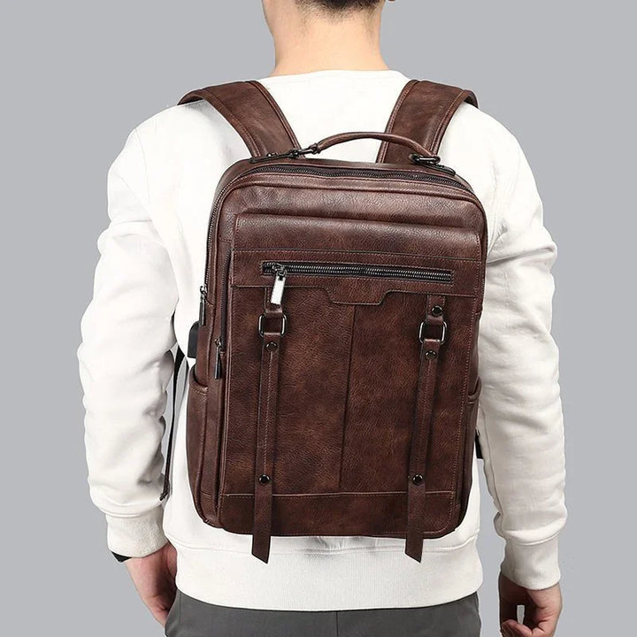 Man wearing stylish brown leather backpack with front zipper pocket and buckle straps