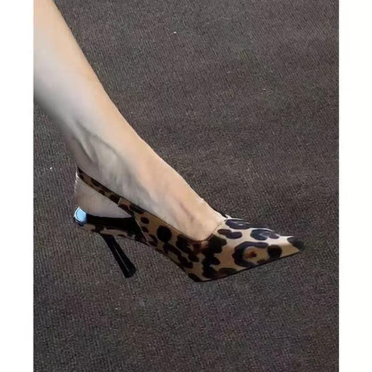 foot wearing leopard print pointed toe slingback high heel shoe on dark carpet
