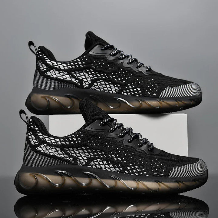 Black and white knit athletic sneakers with wave-patterned translucent sole on gray background