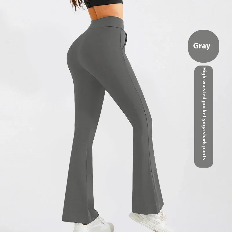 Woman wearing gray high-waisted pocket yoga shank pants with flared legs and white sneakers