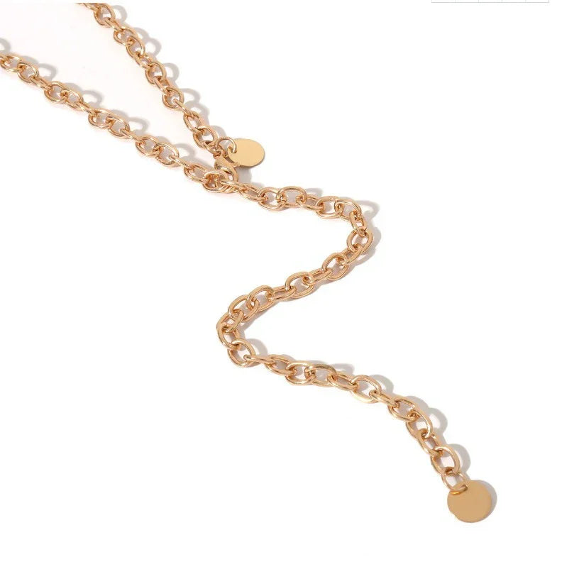 Close-up of a gold chain necklace with round disc charms on a white background