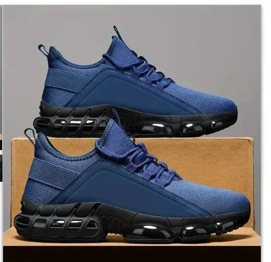 Pair of blue athletic sneakers with black air-cushioned soles on cardboard boxes