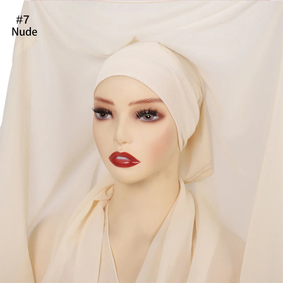 Mannequin head wearing nude-colored hijab and matching fabric background, smoky eye makeup, red lips