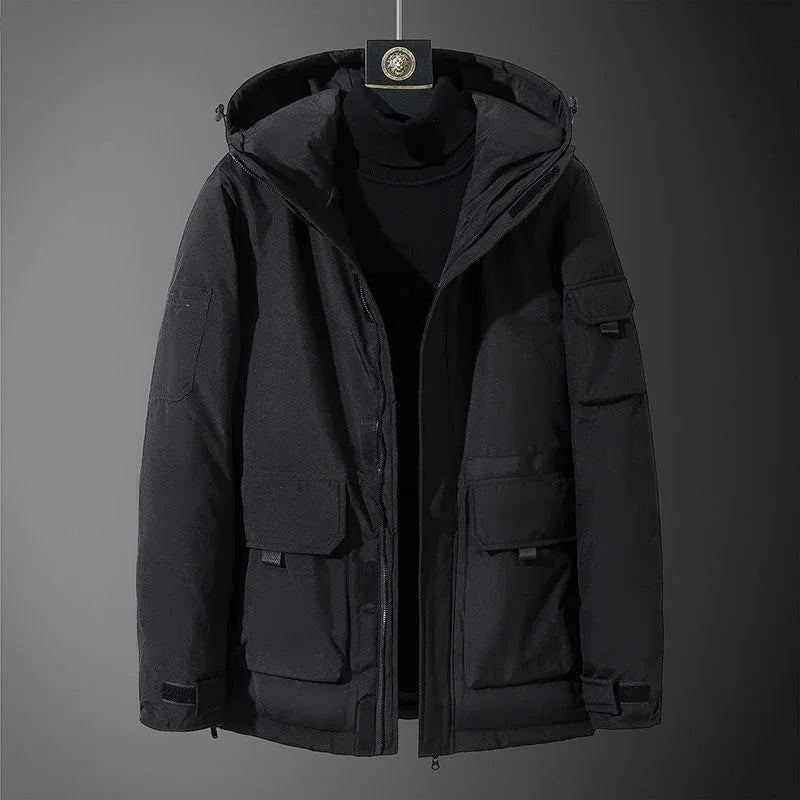 Black hooded winter jacket with front flap pockets and zipper on display against dark background