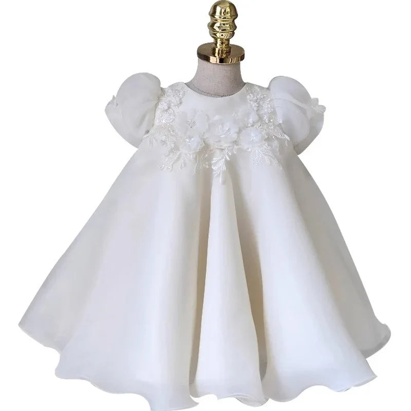 White baby dress with puffed sleeves and floral lace embroidery on bodice displayed on mannequin