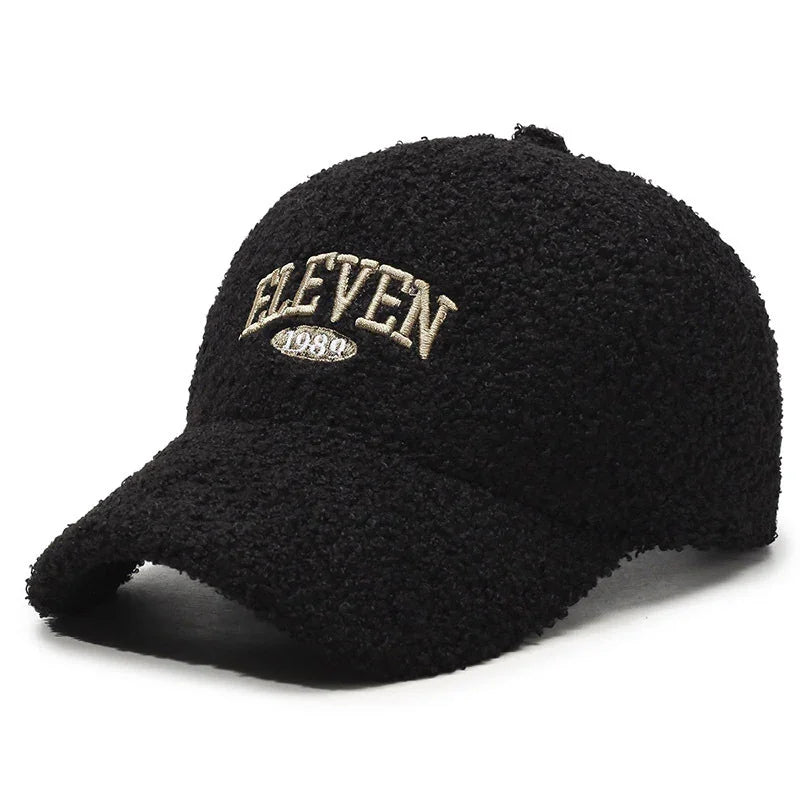 Black textured baseball cap with beige embroidered ELEVEN 1989 logo on the front