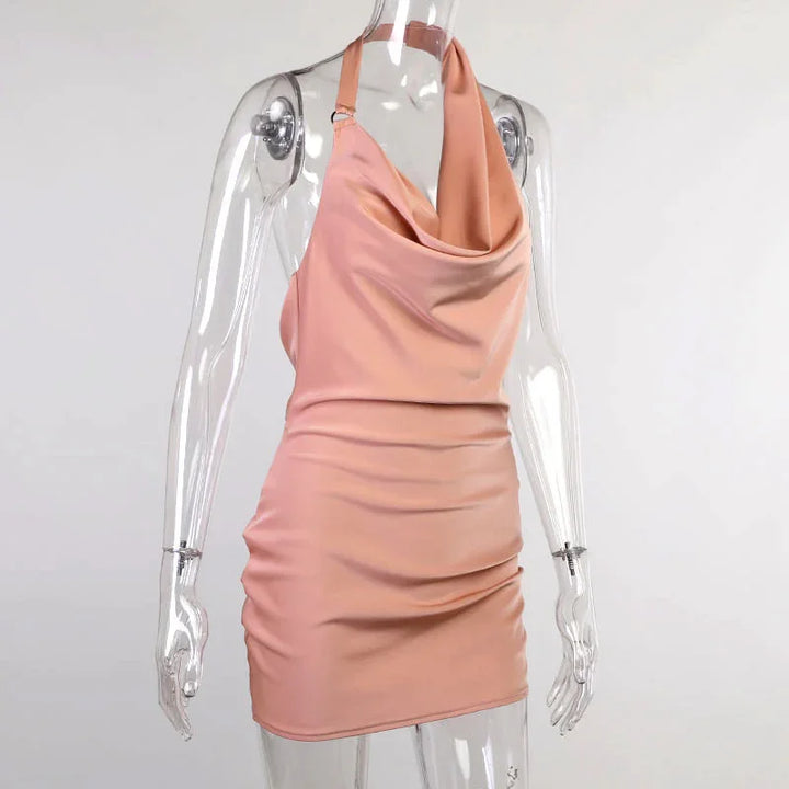 Rose gold satin mini dress with draped halter neckline on clear mannequin