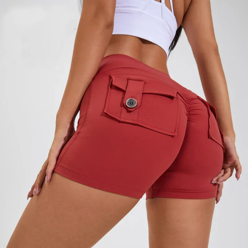 Close-up of woman wearing high-waisted red scrunch butt shorts with button flap pockets and white crop top
