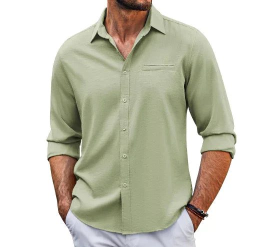 man wearing a light green casual button-up shirt with rolled sleeves and white pants
