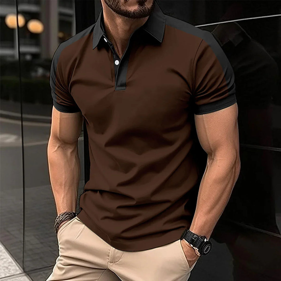 Muscular man wearing brown and black short-sleeve polo shirt with beige pants, standing with hands in pockets