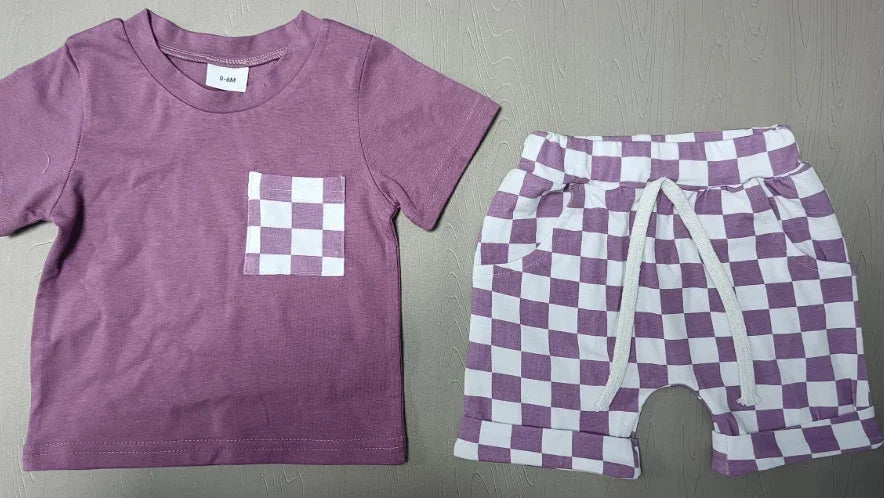 Infant 0-6 month purple t-shirt with checkered pocket and matching checkered shorts on gray surface