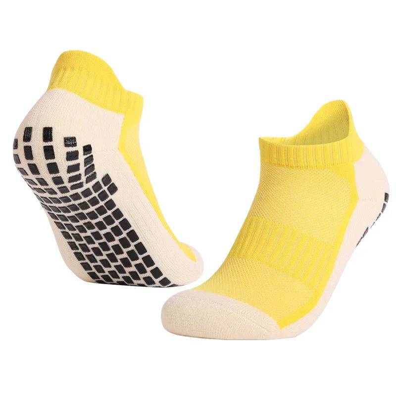 Pair of yellow and beige no-show grip socks with black non-slip sole pads
