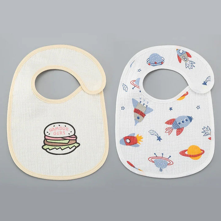 Two baby bibs on gray background, one with hamburger print, the other with colorful space rocket and planet designs