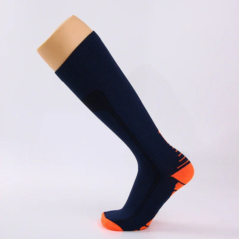 Knee-high navy blue compression sock with bright orange heel and toe accents on display mannequin