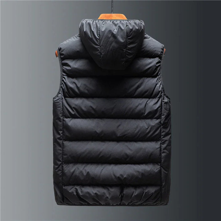 Black padded sleeveless puffer vest with hood hanging against gray background