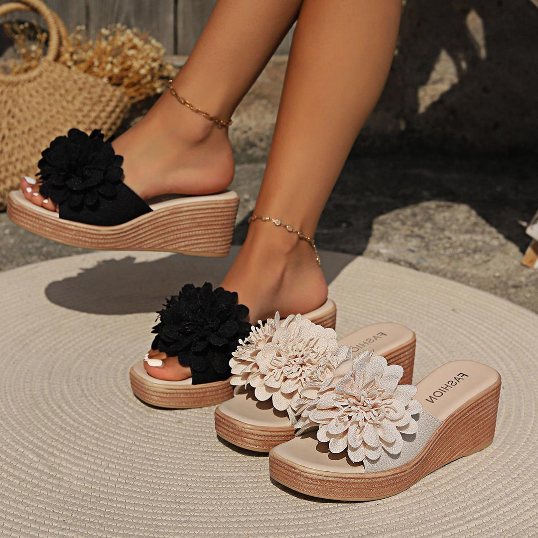 Woman wearing black floral wedge sandals with beige wedge sandals displayed on a round mat outdoors