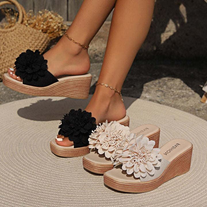Woman wearing black floral wedge sandals with beige wedge sandals displayed on a round mat outdoors