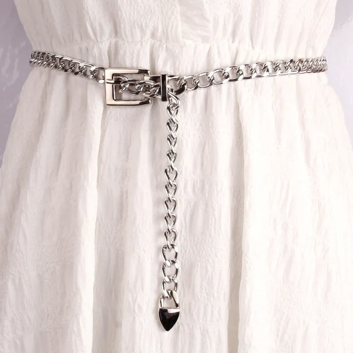 Silver chain belt with buckle detail worn on textured white fabric dress