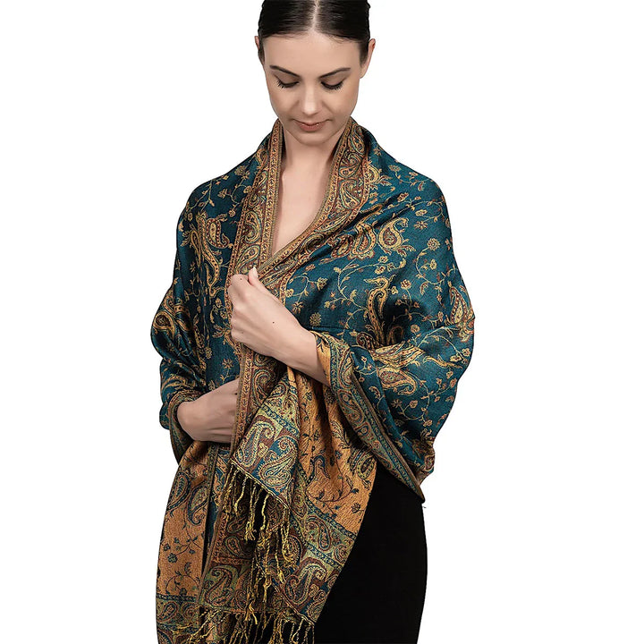Woman wearing elegant teal and gold paisley patterned shawl with fringe detail