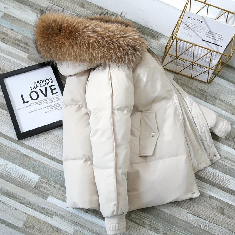 Beige puffer jacket with brown fur hood on wooden floor near framed love quote and gold wire basket